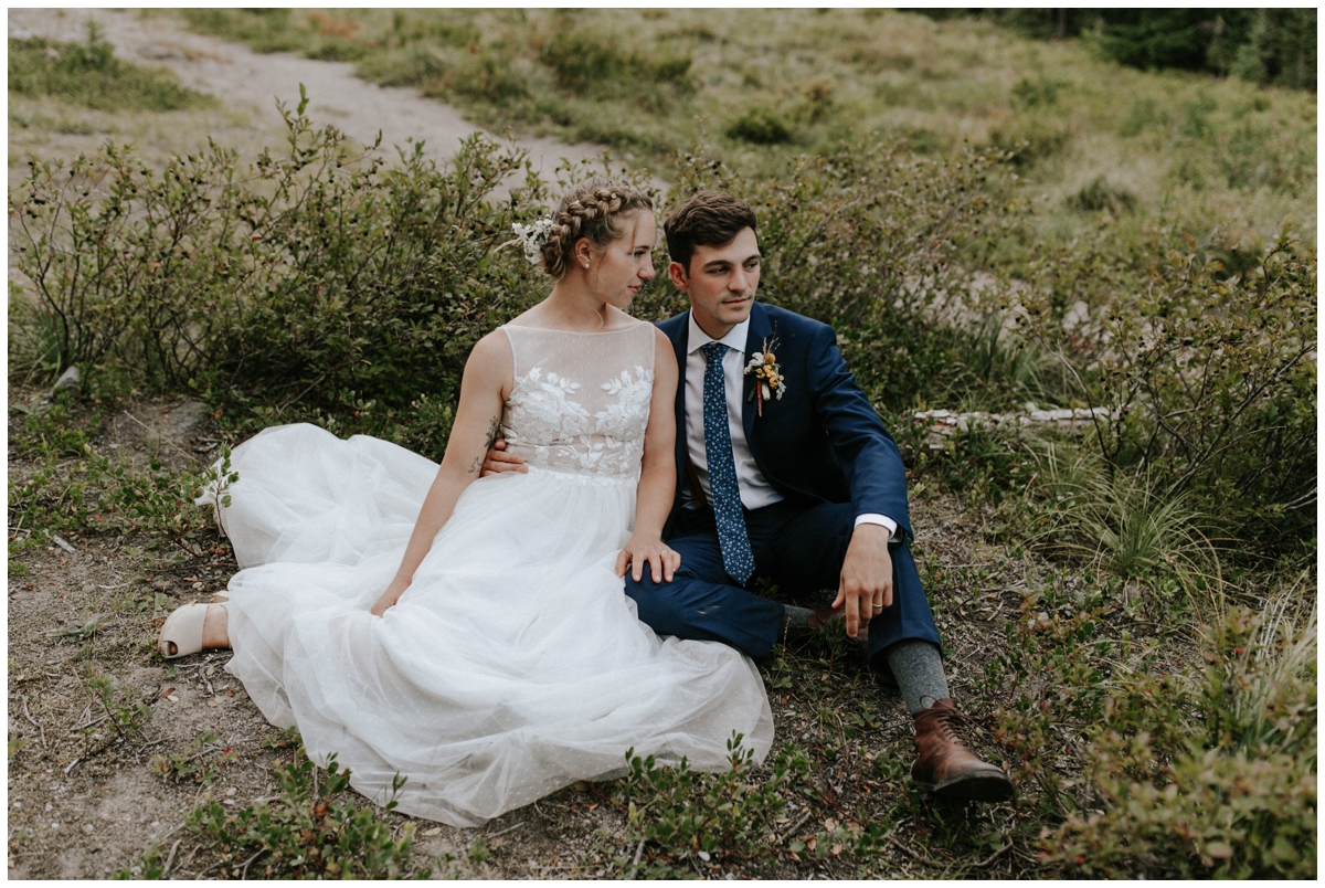 bride and groom sitting in brush